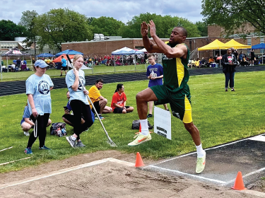 athlete in mid jump into sand pit